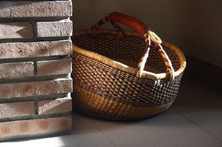 In a home, a basket sits in the sunlight. 
