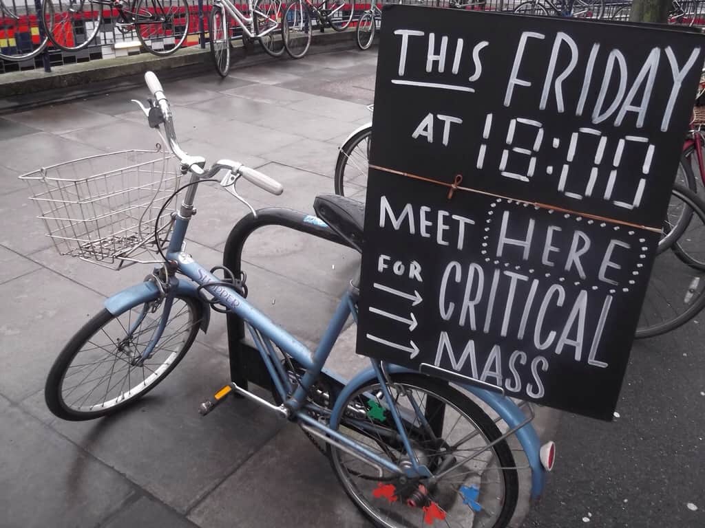 Bike with a basket carrying a sign that says "This Friday, meet here for critical mass."