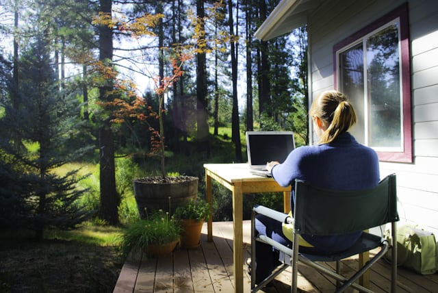 Working on a laptop in a rural backyard. 