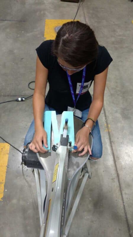 Girl using a band saw to cut a letter out of a book