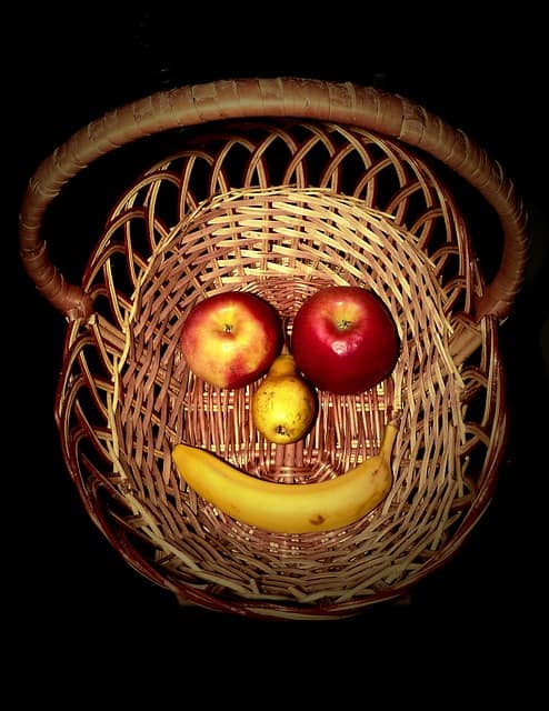 Basket with happy face made of fruit