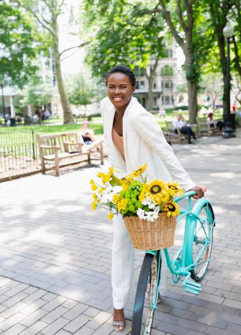 Woman with a bicycle basket of bright flowers