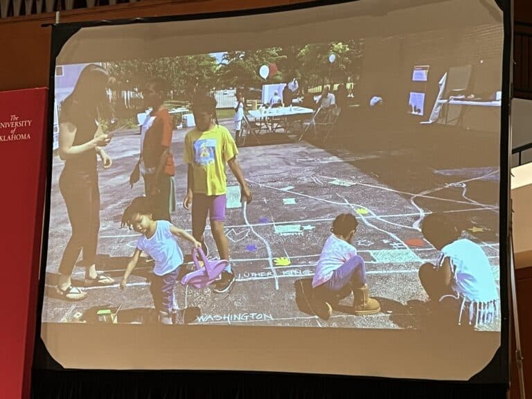 Kids playing on a chalked map of their community