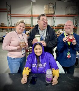Four workers hold candles and smile for the camera