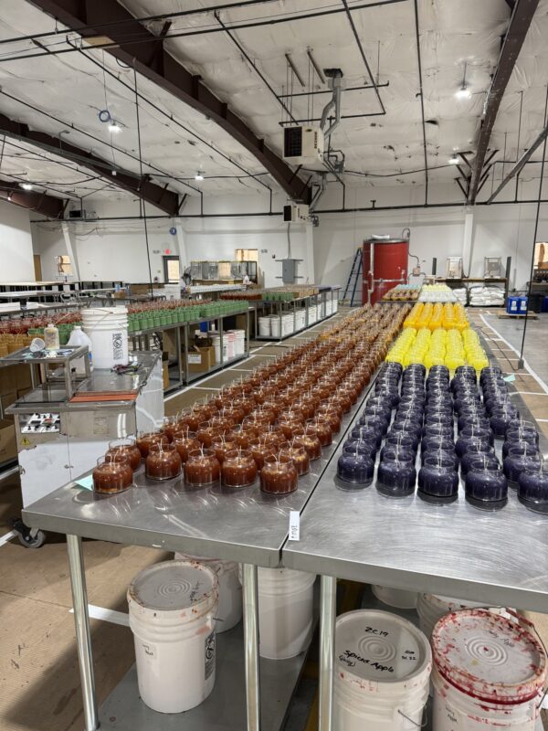 A stainless steel table covered with candles in progress